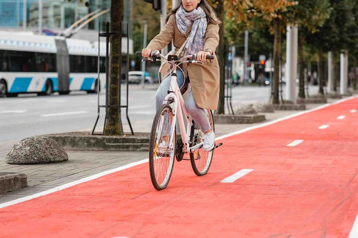 woman-riding-bicycle-along-red-bike-lane-city